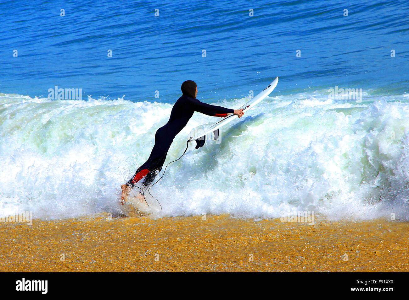 Hot Shot Surfer Sprung ins Meer unter Herausforderung und Risiko Stockfoto