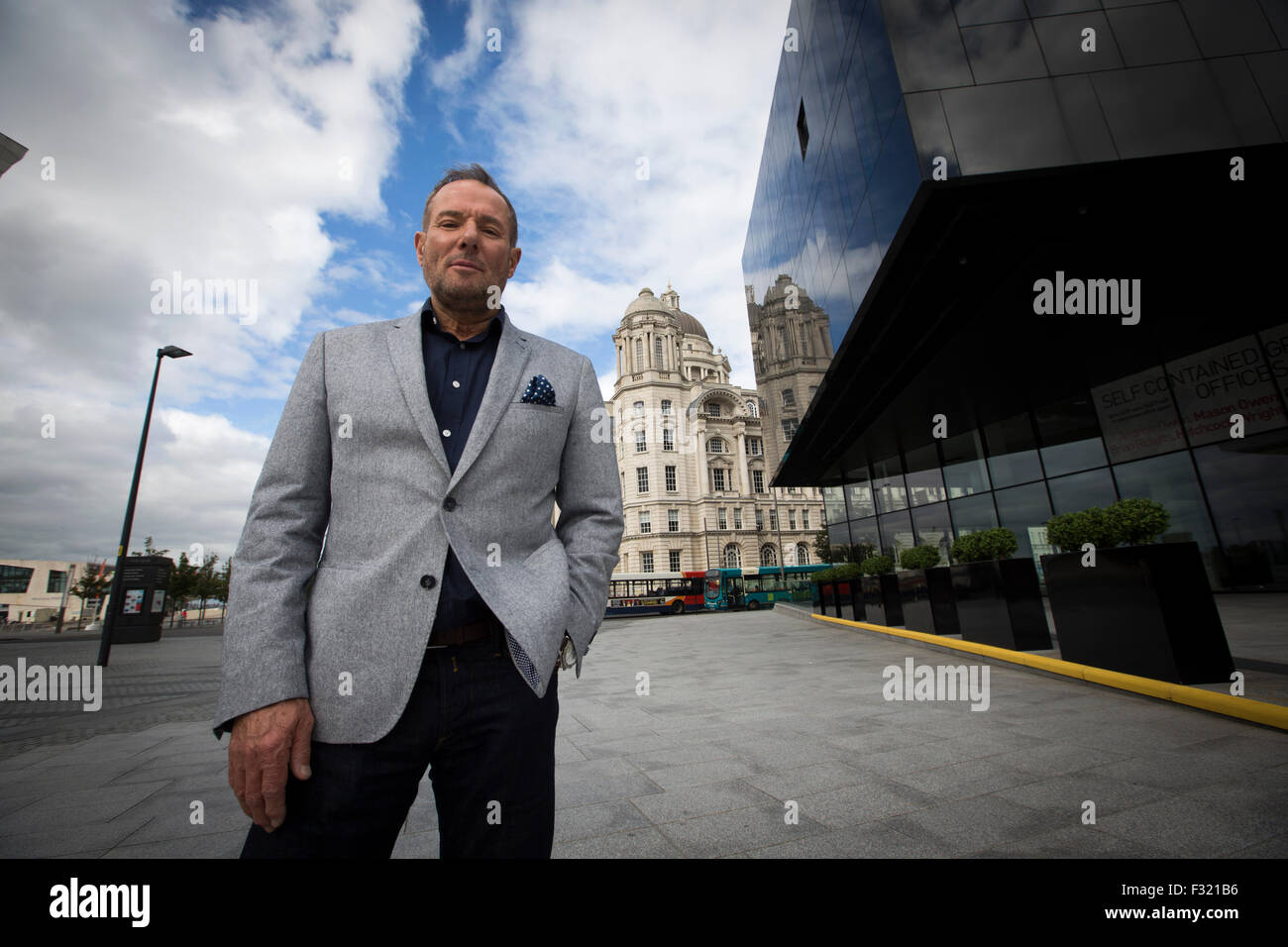 Ehemalige linke britische Politiker, Derek Hatton, in seiner Heimatstadt von Liverpool, mit dem legendären Leber-Gebäude im Hintergrund abgebildet. Hatton ist ein ehemaliger Politiker, Sender, Bauträger, Geschäftsmann und after-Dinner-Speaker. Er sammelte nationale Prominenz als Kommunalpolitiker in Liverpool in den 1980er Jahren, wo er war stellvertretender Vorsitzender des Stadtrates, und ein Mitglied der militanten trotzkistischen Gruppe brachte ihn in Konflikt mit der Labour Party und die dann konservative Regierung von Margaret Thatcher. Stockfoto