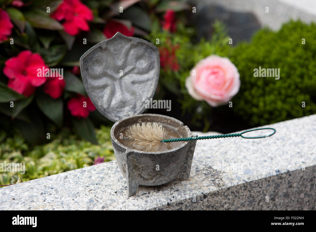 Nahaufnahme einer Weihwasser Schale am Grab Stockfoto