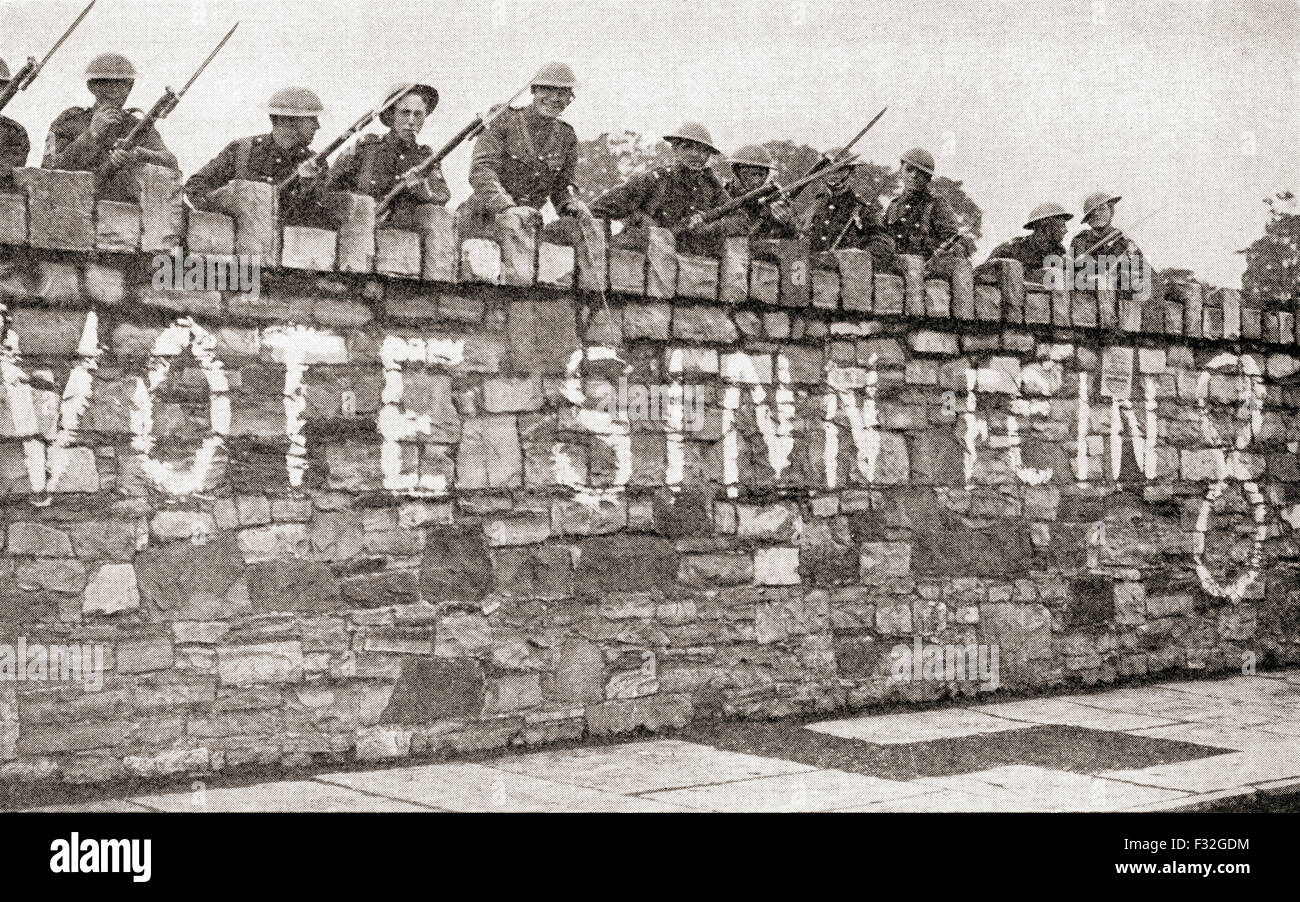 Britische Truppen bewachen eine Wand, die mit einer Sinn Féin Werbung während Irischer Krieg von Unabhängigkeit aka Anglo-Irischer Krieg, im Jahre 1920 verputzt ist. Stockfoto