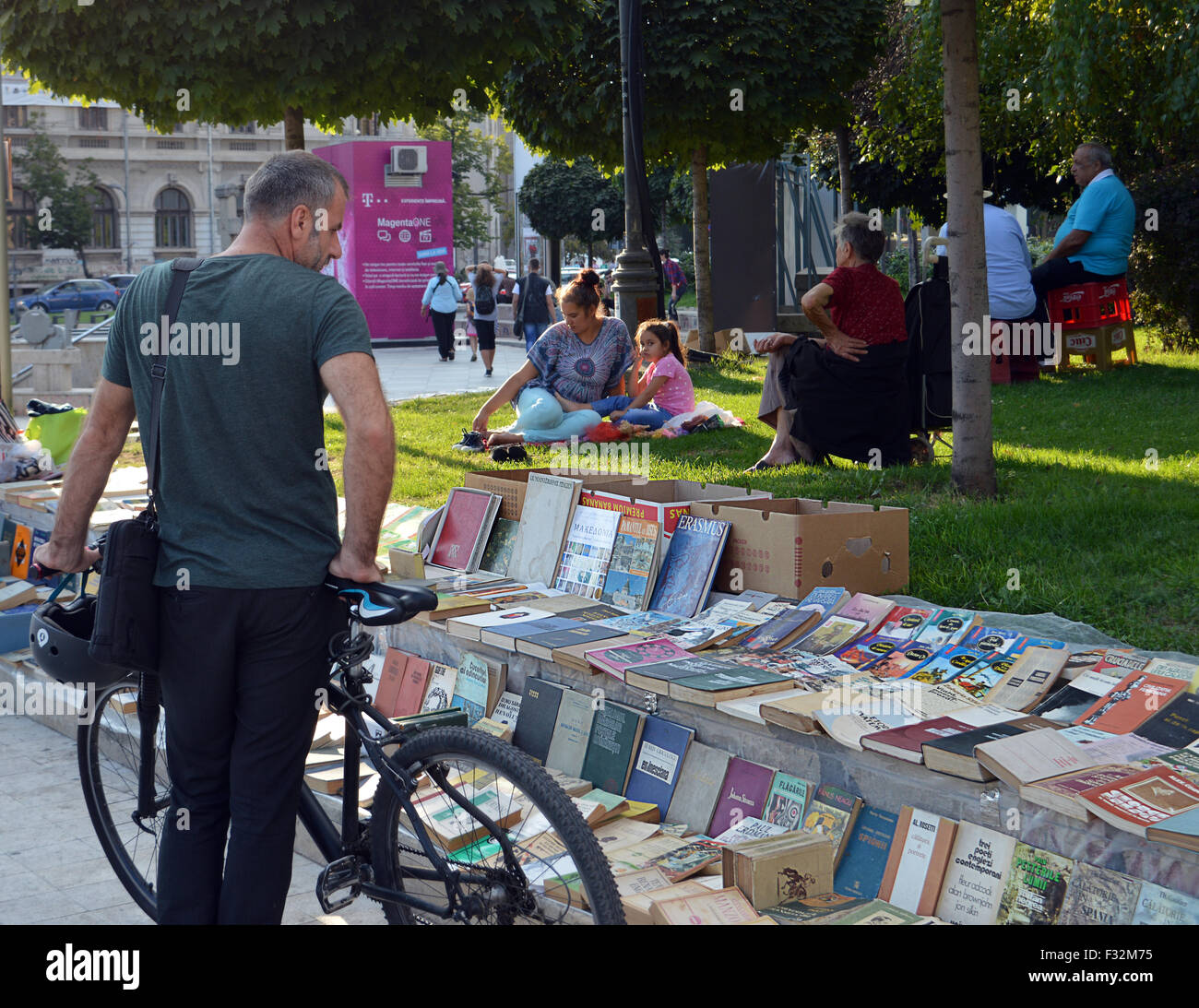 Ein Radfahrer hält um Bücher auf dem Bürgersteig am Piata Universitatii (Universitätsplatz) im Zentrum von Bukarest zu betrachten. Stockfoto