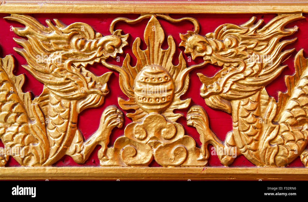 Goldener Drache auf roten Holz Wand dekoriert. Stockfoto