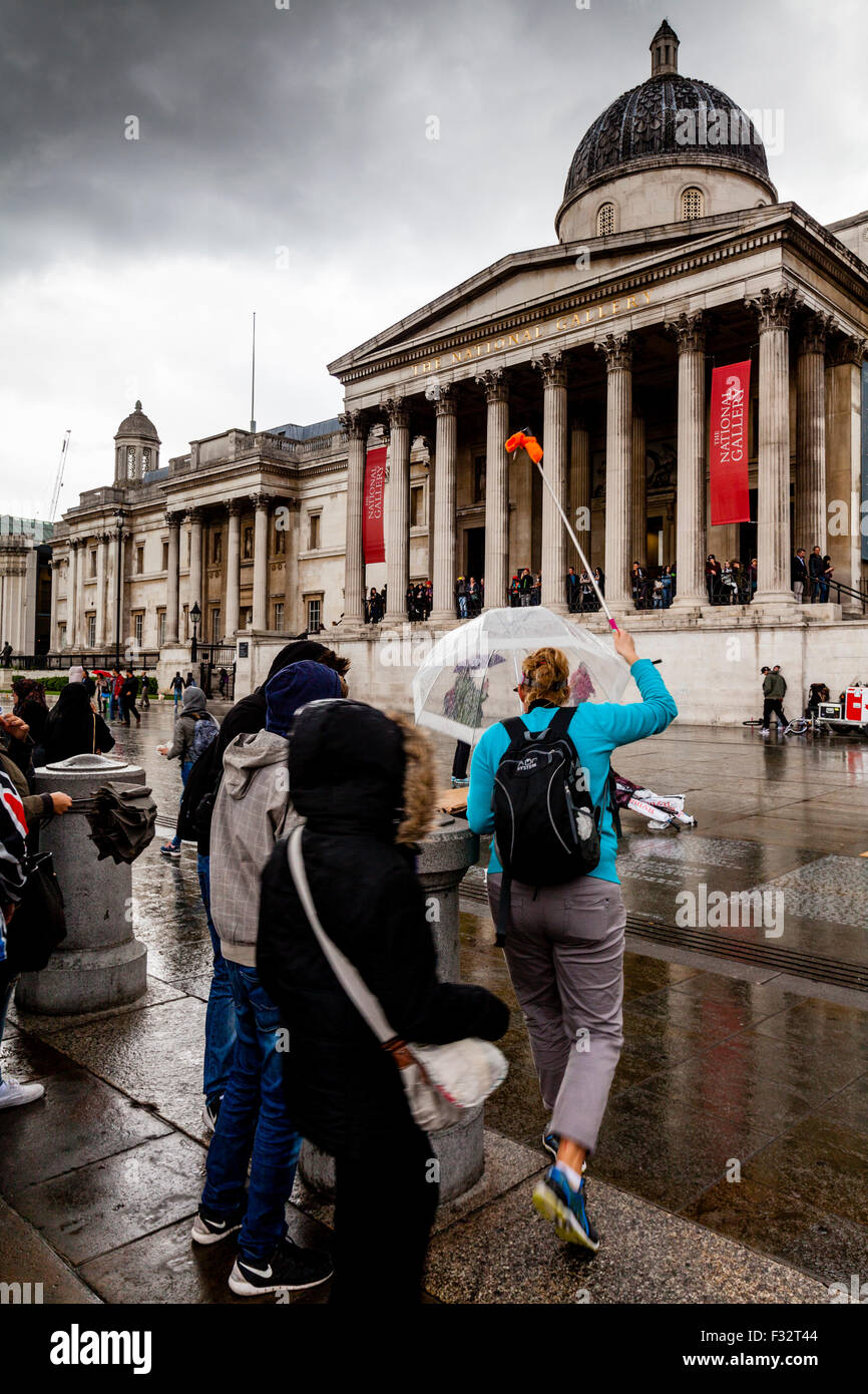 Besuchern stehen außerhalb der Nationalgalerie im Regen, London, UK Stockfoto