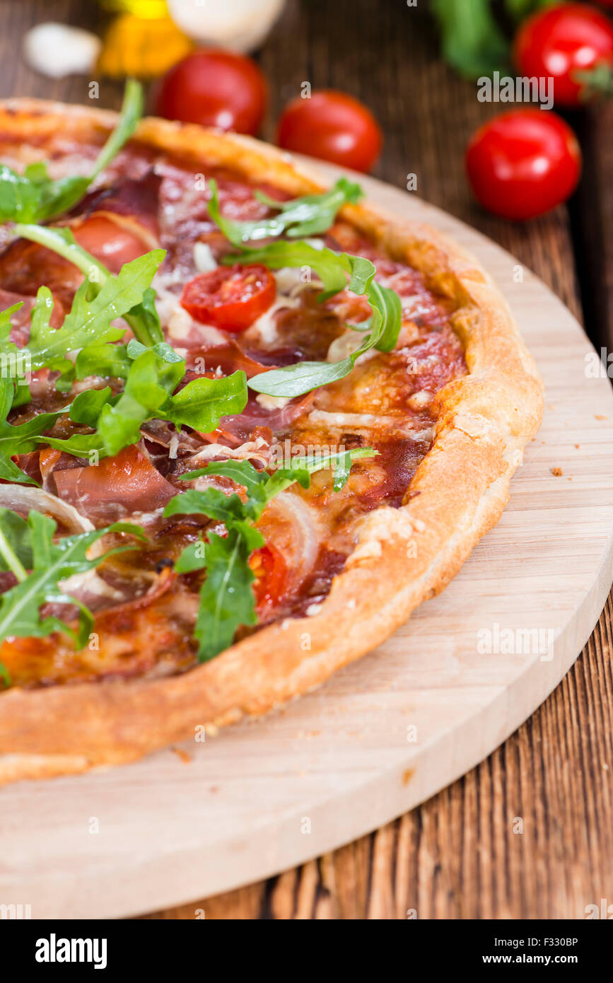 Hausgemachte Schinken Pizza (mit Rucola, frischen Tomaten, Knoblauch und Käse) Stockfoto