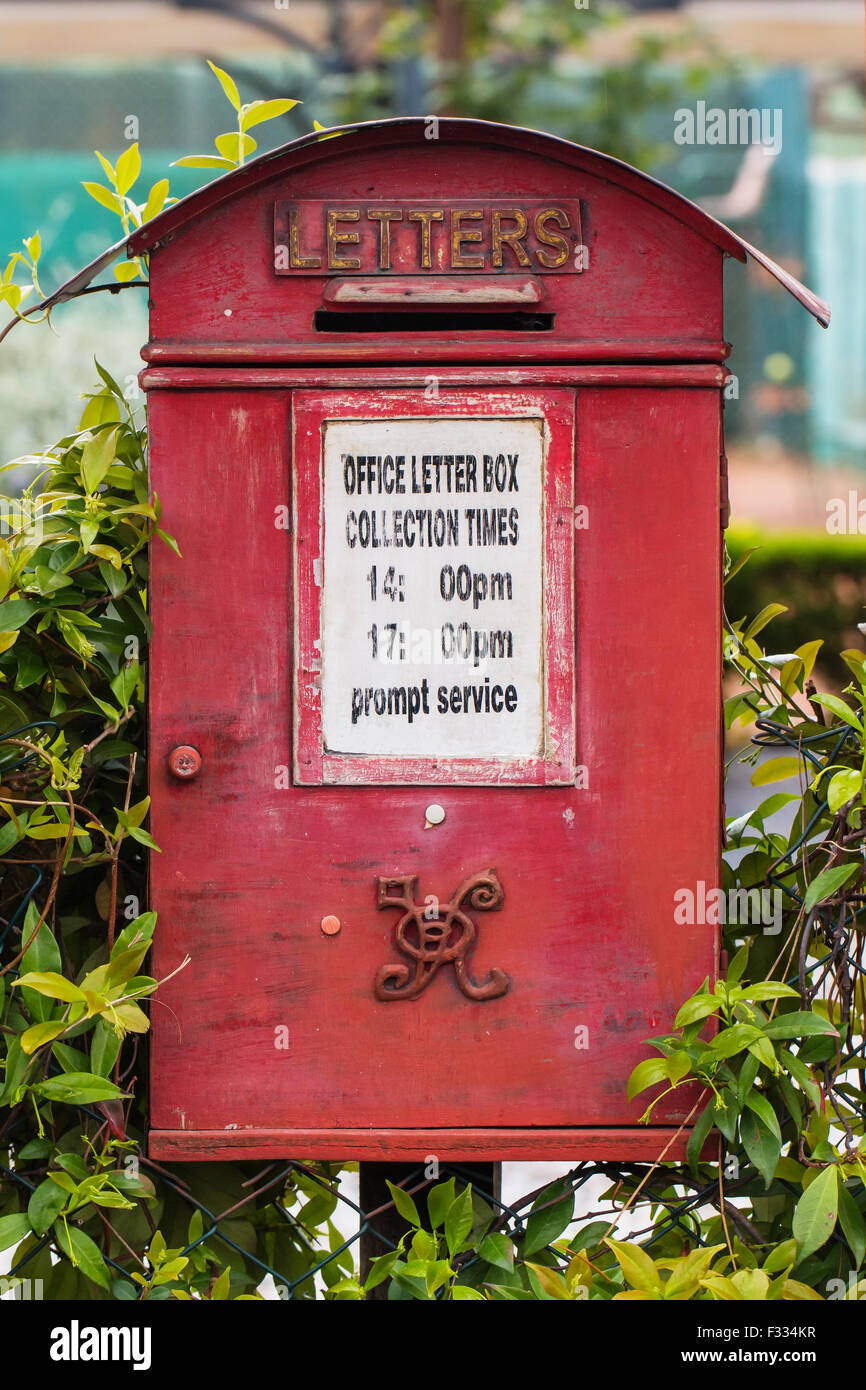 Alte königliche Post-Briefkasten lackiert in rot mit Königin Victoria Monogramm und Sammlung Zeitanzeige Stockfoto