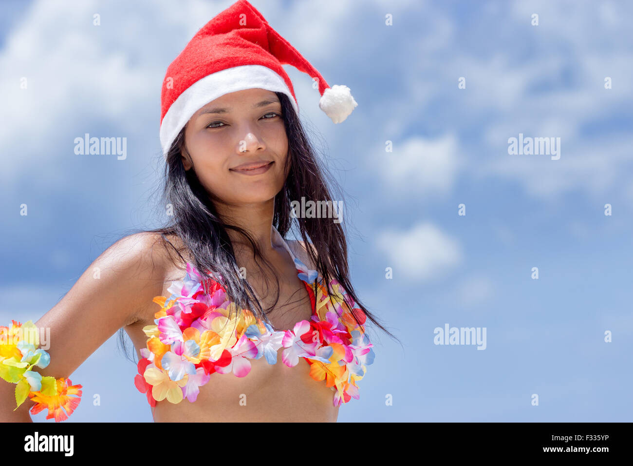 Hawaii Hula-Tänzerin mit Hut von Santa Claus auf blauem Hintergrund Stockfoto