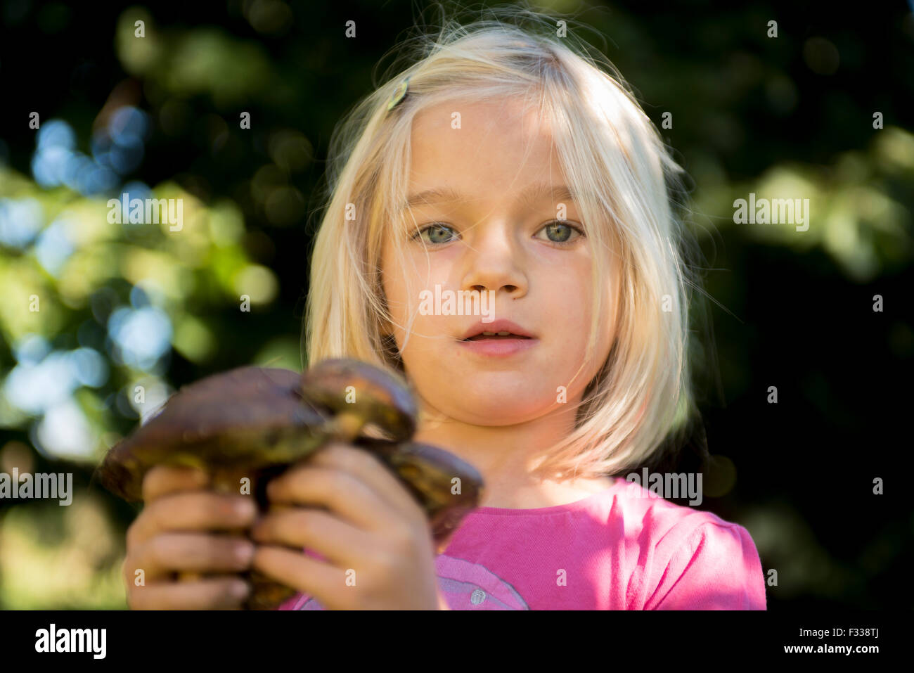 Porträt von Kind blondes Mädchen Abholung Pilze im Wald, machen Spaß, Sommer, Wald, Holz, Wald Stockfoto