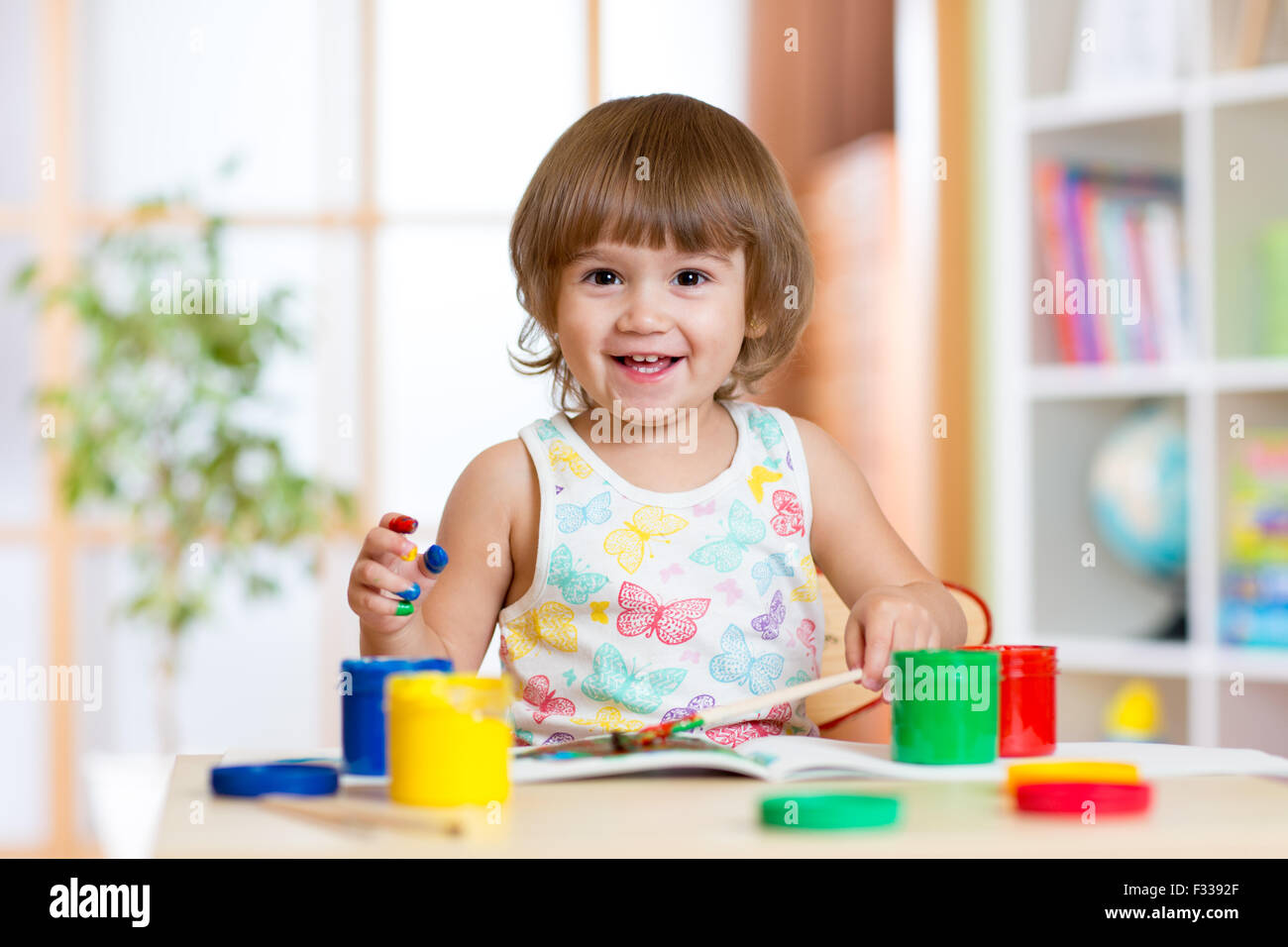 Glückliches Kind Mädchen mit Händen lackiert Farbe Farben Stockfoto