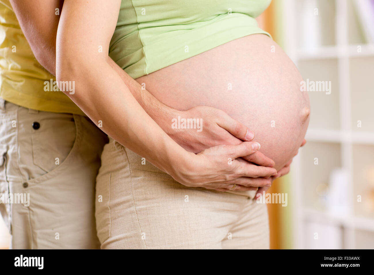 Mann umarmt seine schwangere Frau Stockfoto