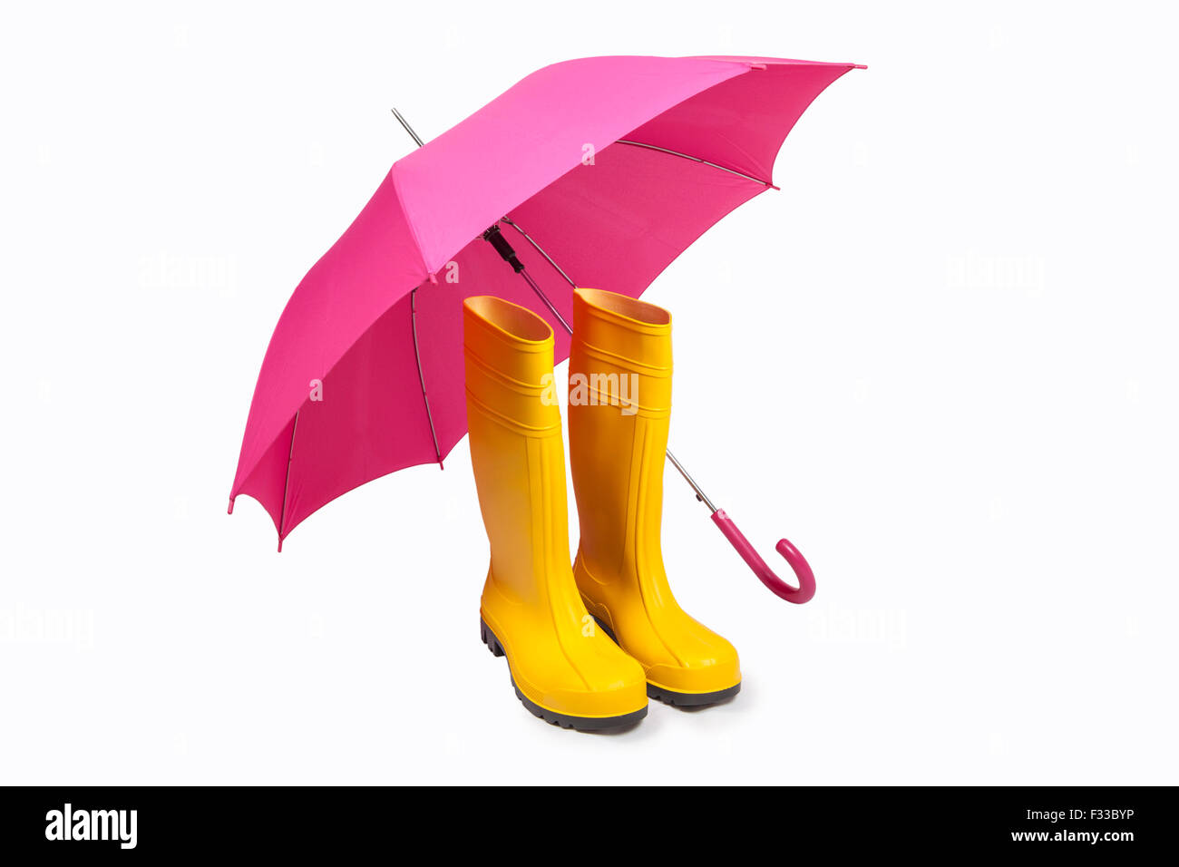 Gelbe Gummistiefel und rosa Umbreall isoliert Stockfoto