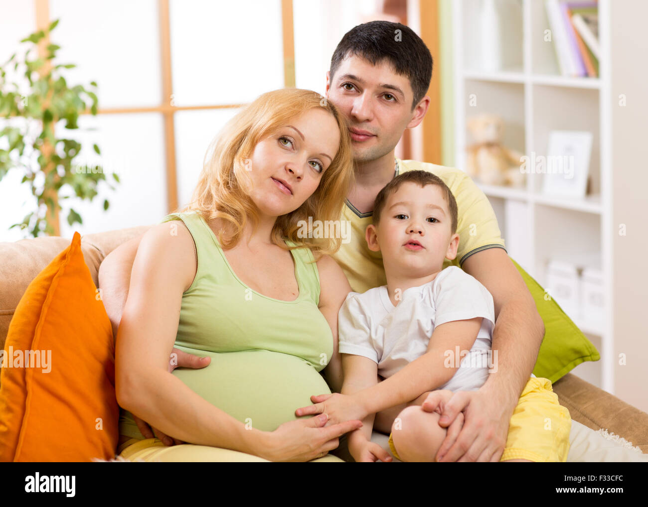 Glückliche Familie erwartet Baby. Schwangere Frau mit Mann und Sohn zusammen Stockfoto