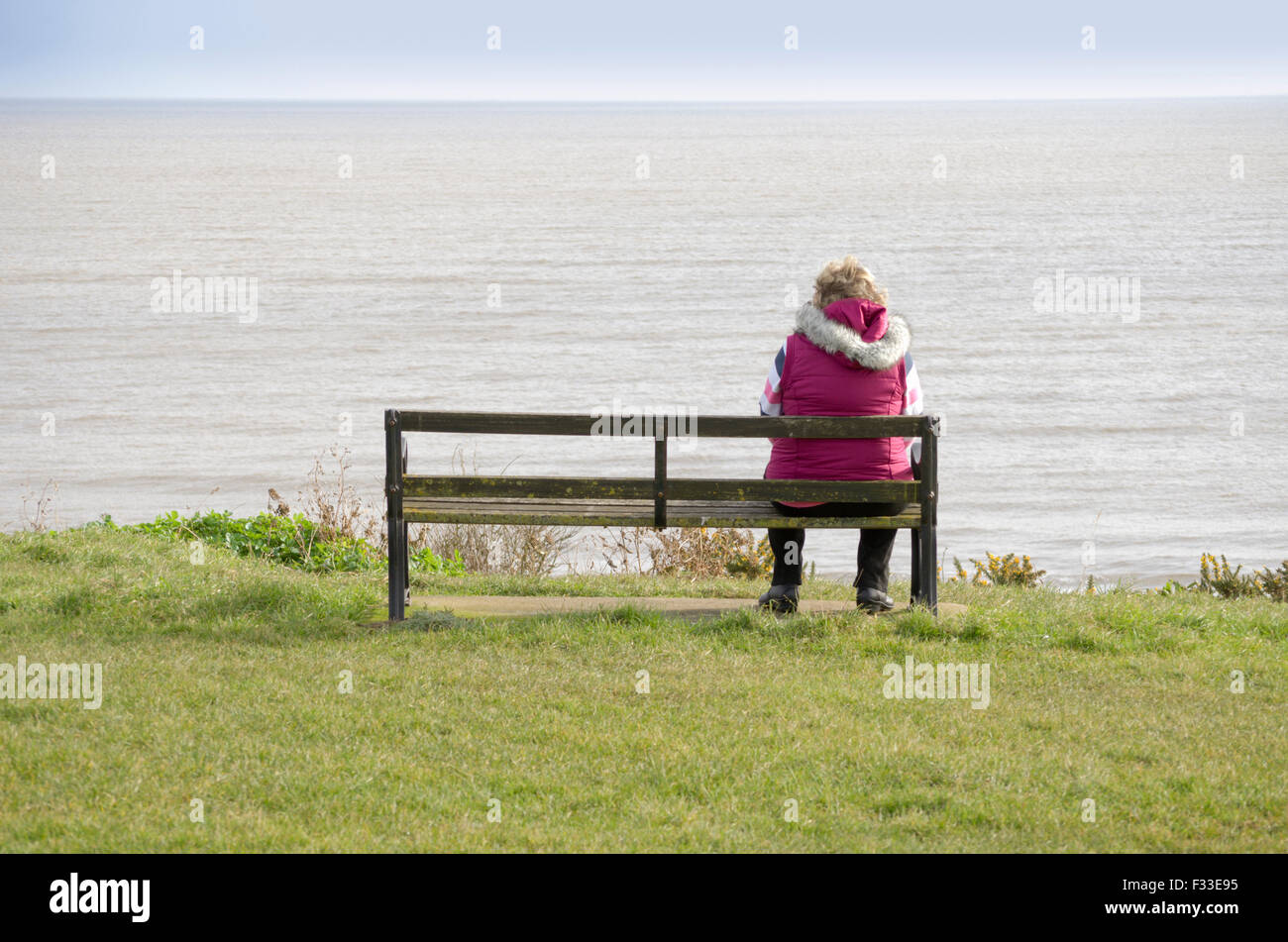 Eine Frau sitzt auf einer Bank Stockfoto