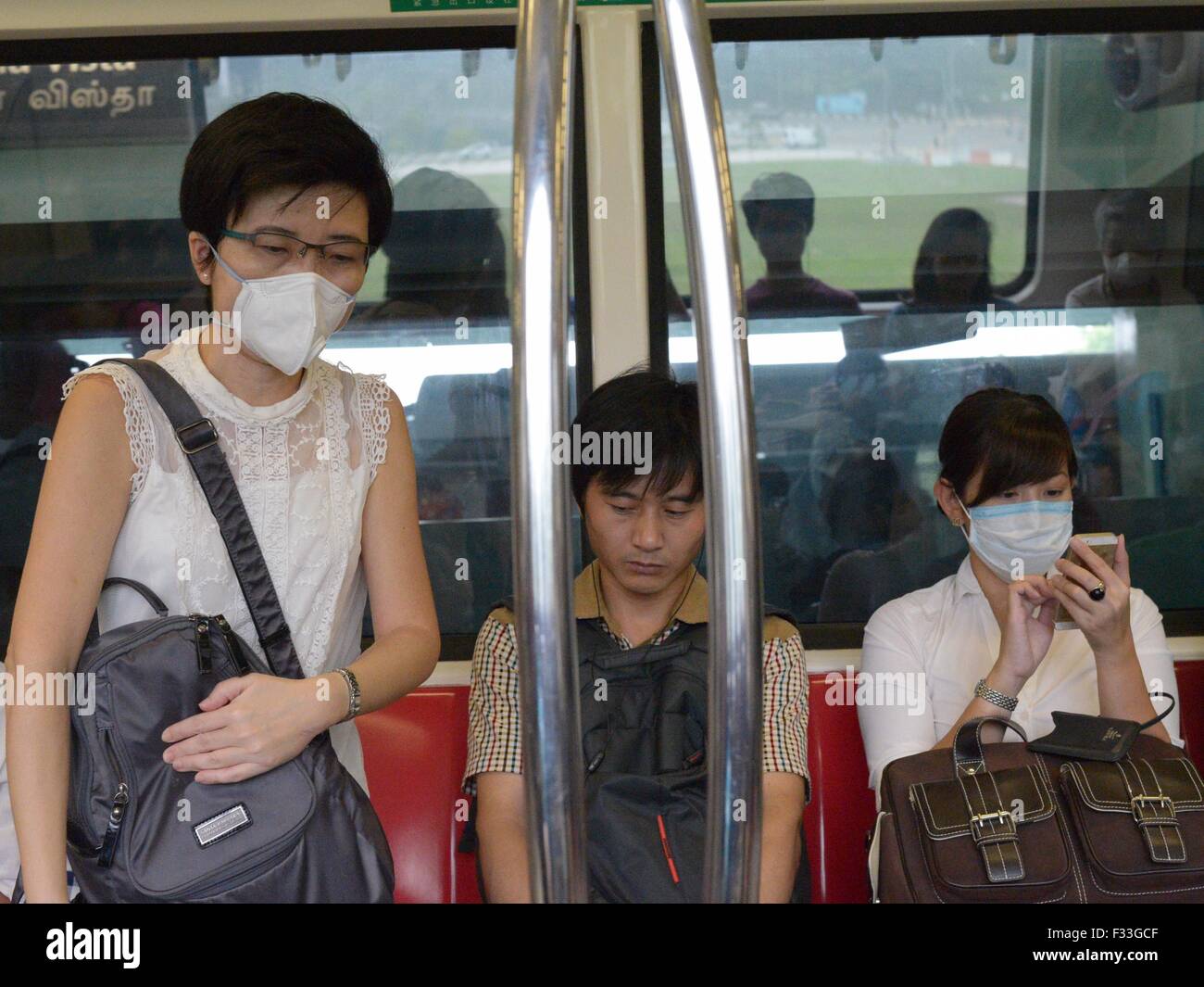 Singapur. 29. Sep, 2015. Passagiere, die mit Masken nehmen Sie die u-Bahn in Singapur, 29. September 2015. Die dreistündige Schadstoffe Standard Index (PSI) von Singapur 250 um 14:00 Ortszeit am Dienstag getroffen und "sehr ungesunde" Niveau erreicht. © Dahin Chih Wey/Xinhua/Alamy Live-Nachrichten Stockfoto