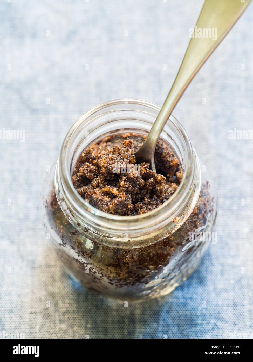 Hausgemachte Gesichts- und organischen alle natürlichen Kaffee scrub (peeling) in einem Glas. Löffel im Inneren platziert. Vertikale Ausrichtung. Stockfoto