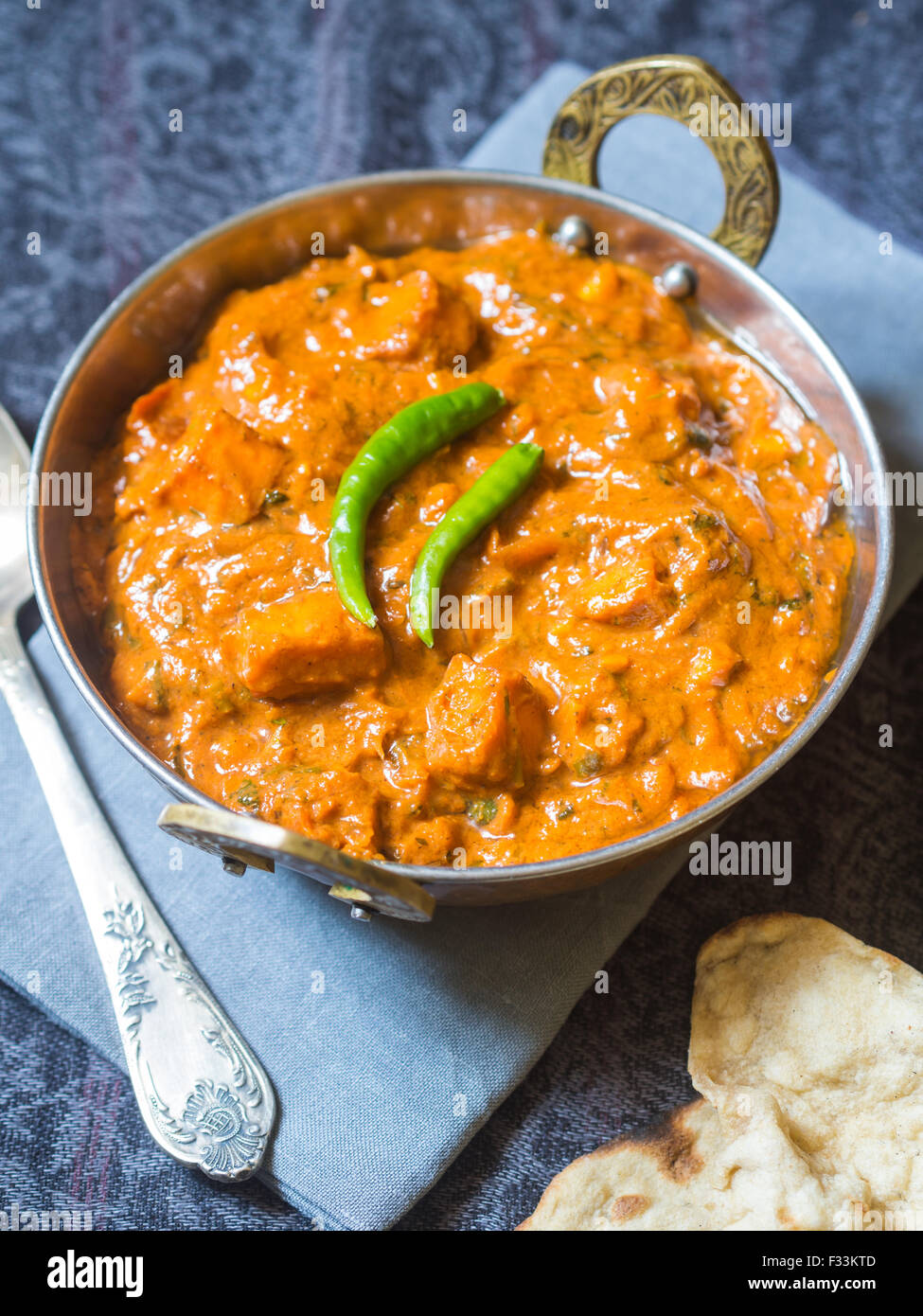 Paneer Tikka Masala (indische Küche) in einer traditionellen Kupfer Schüssel mit tandoori Roti serviert. Stockfoto