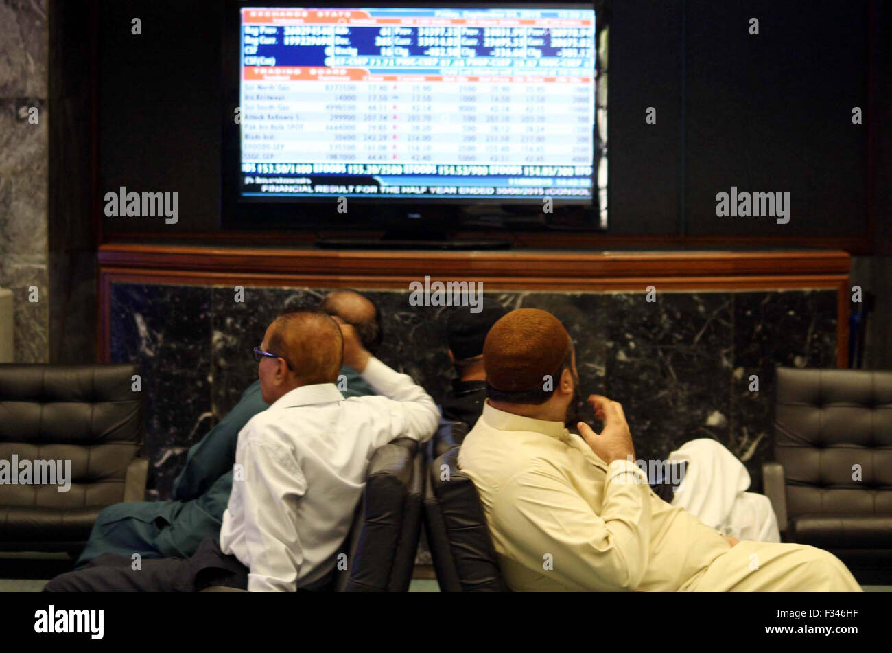 Börsenmakler sind beschäftigt bei der Überwachung der Aktienkurse während der Handelszeit an der Karachi Stock Exchange (KSE) in Karachi auf Dienstag, 29. September 2015. Stockfoto