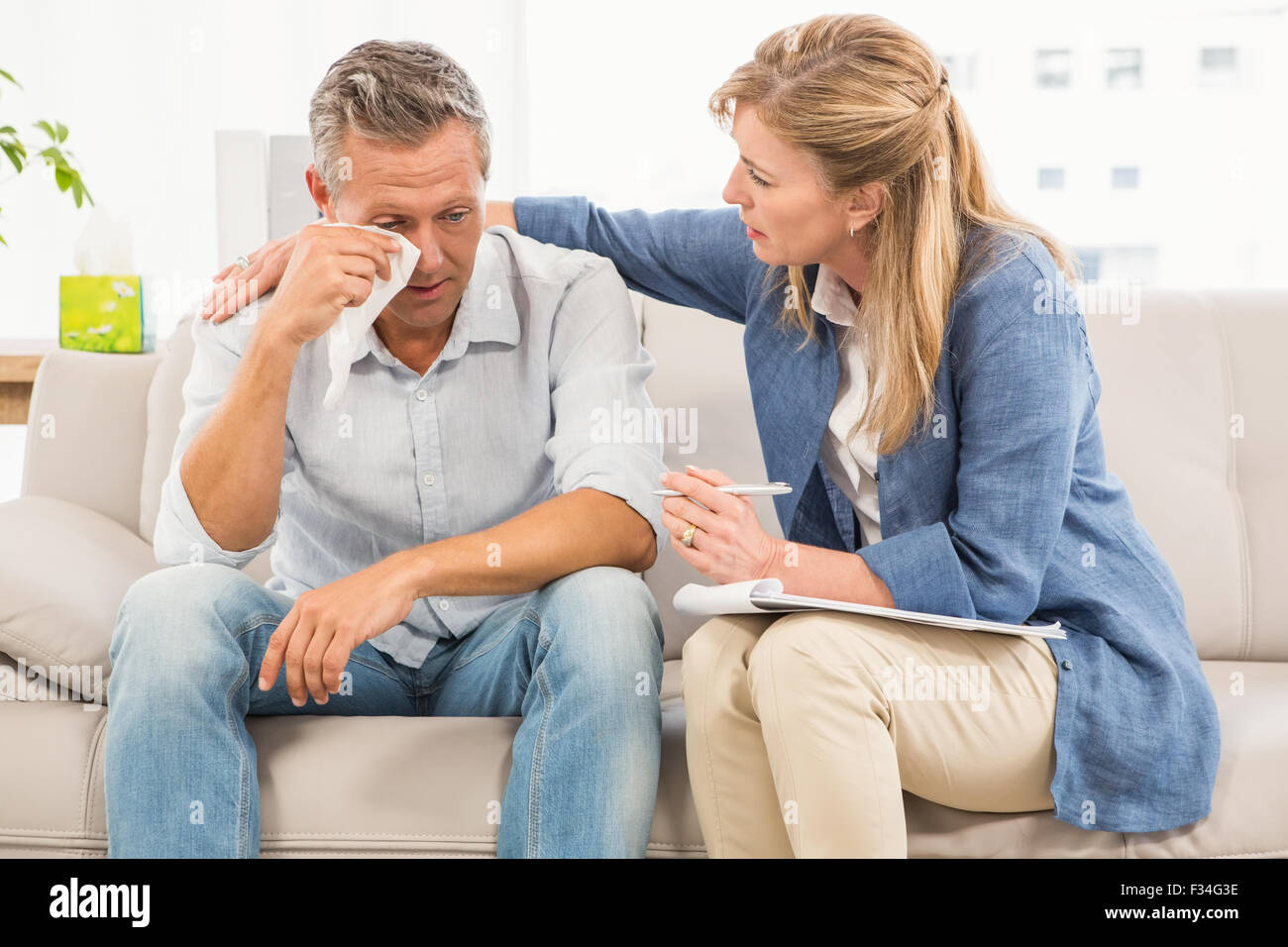 Betreffenden Therapeuten trösten weinenden männlichen patient Stockfoto