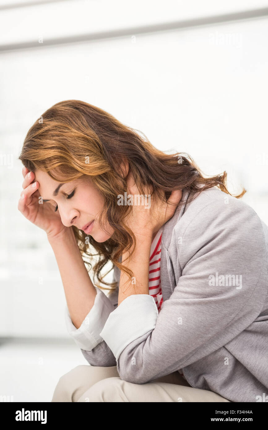 Überarbeitete casual Geschäftsfrau mit Kopfschmerzen Stockfoto