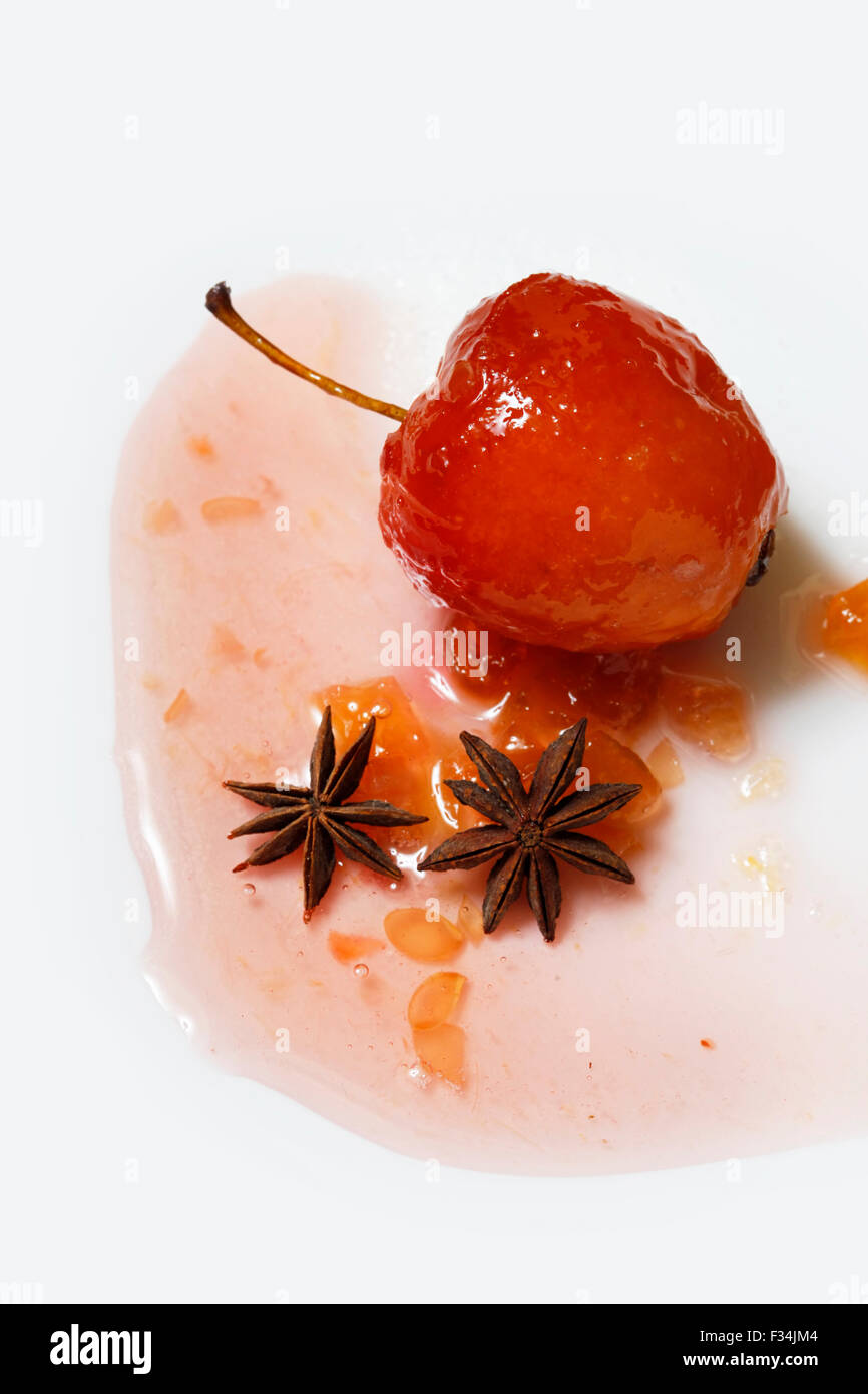 Roter Apfel in rose Sirup mit kleinen Stücken von Zucchini und mit Anis über isolierte weißen Hintergrund Stockfoto