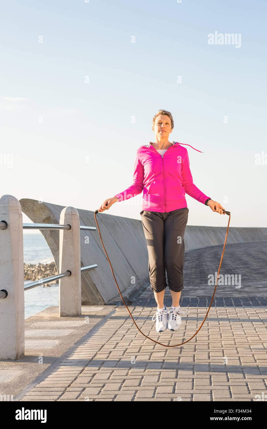 Sportliche Frau, die auf der Promenade überspringen Stockfoto