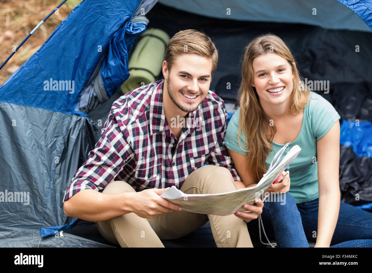 Junge hübsche Wanderer paar sitzt in einem Zelt, Blick in die Kamera Stockfoto