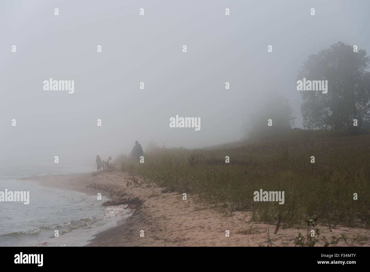 In der dichten Nebeldecke verschwinden Strandwanderer bläst das Wasser des Lake Michigan.  Point Beach State Forest, Wisconsin Stockfoto