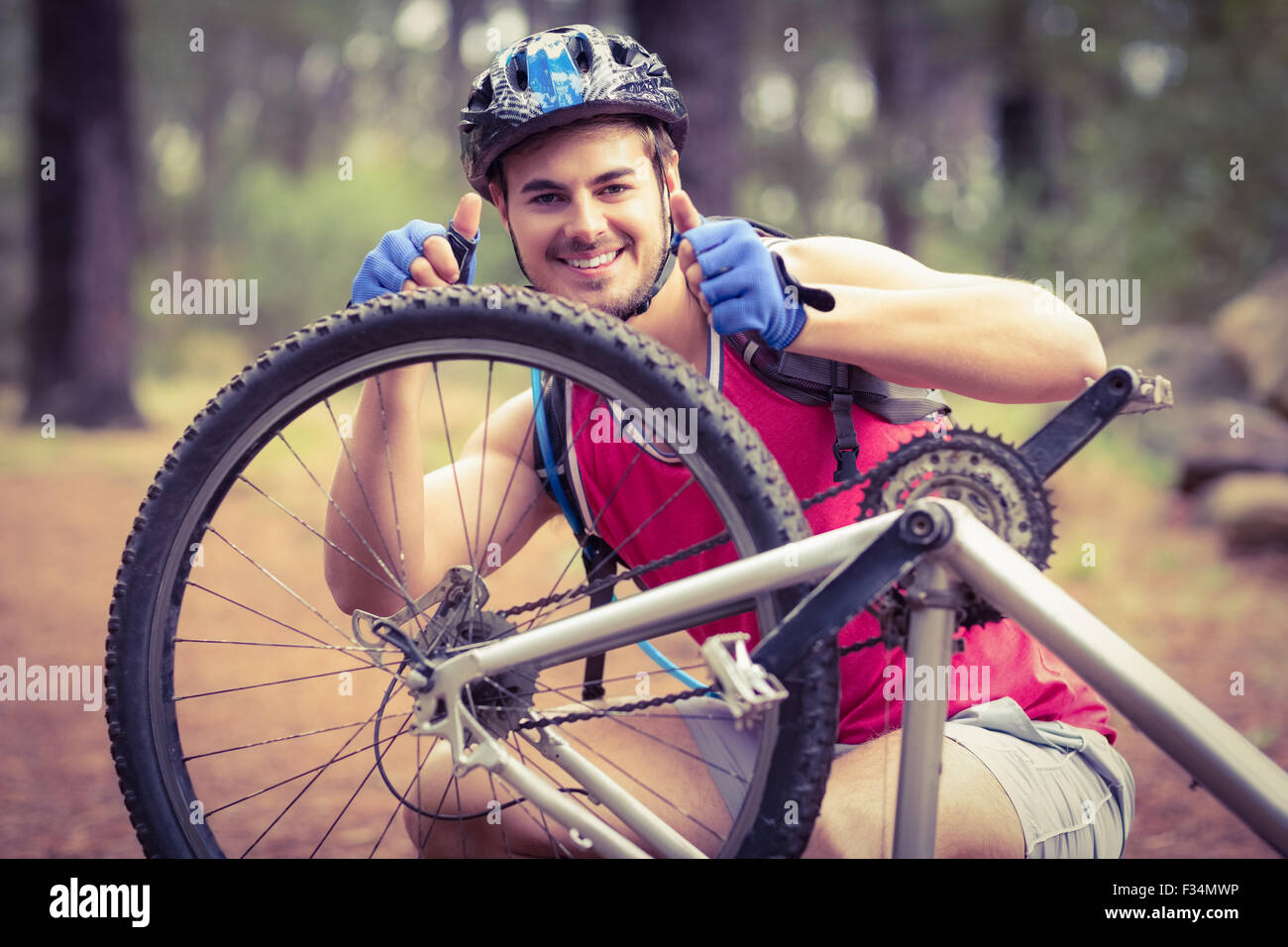 Glücklich schöne Biker Reparatur Fahrrad zeigt Daumen hoch Stockfoto