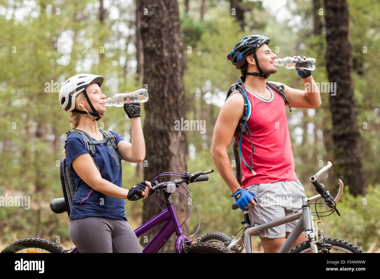 Glücklich, gut aussehend Biker paar Trinkwasser Stockfoto