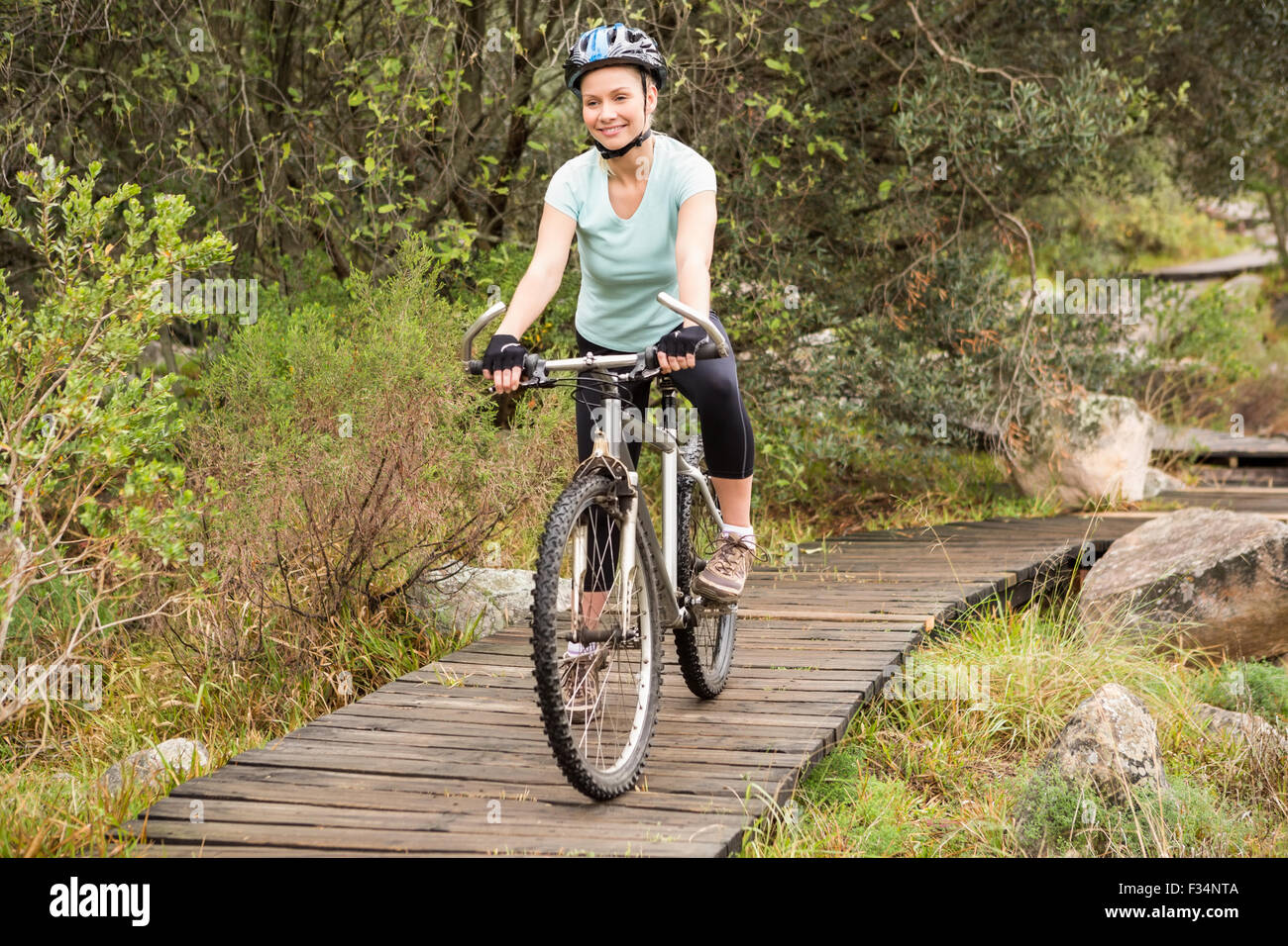 Lächelnde Frau, die ihr Fahrrad Radfahren passen Stockfoto