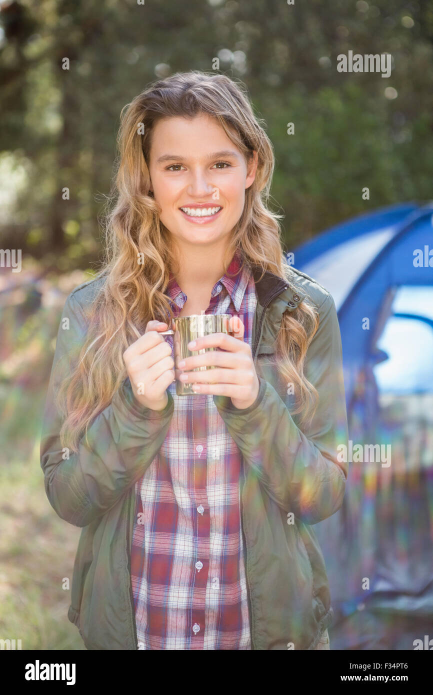 Lächelnde blonde Wohnmobil vor Zelt Stockfoto