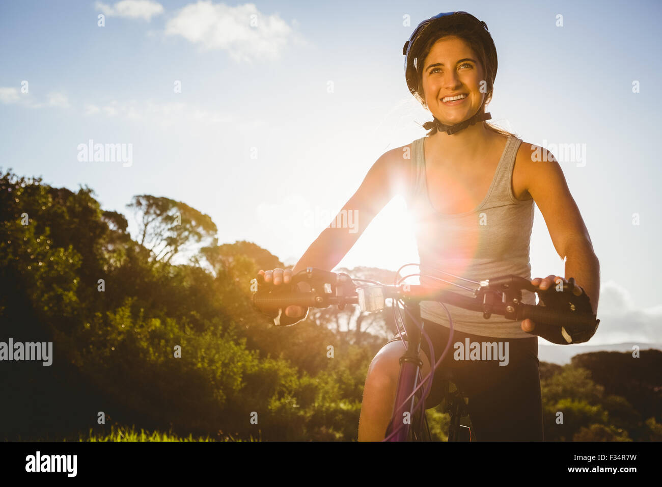 Lächelnd, sportliche Brünette sitzen auf Mountainbike Stockfoto