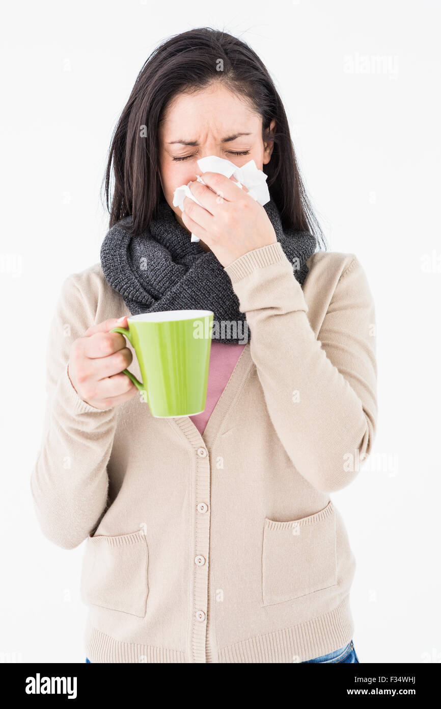 Kranke Frau bläst ihre Nase halten Sie einen grünen Becher Stockfoto