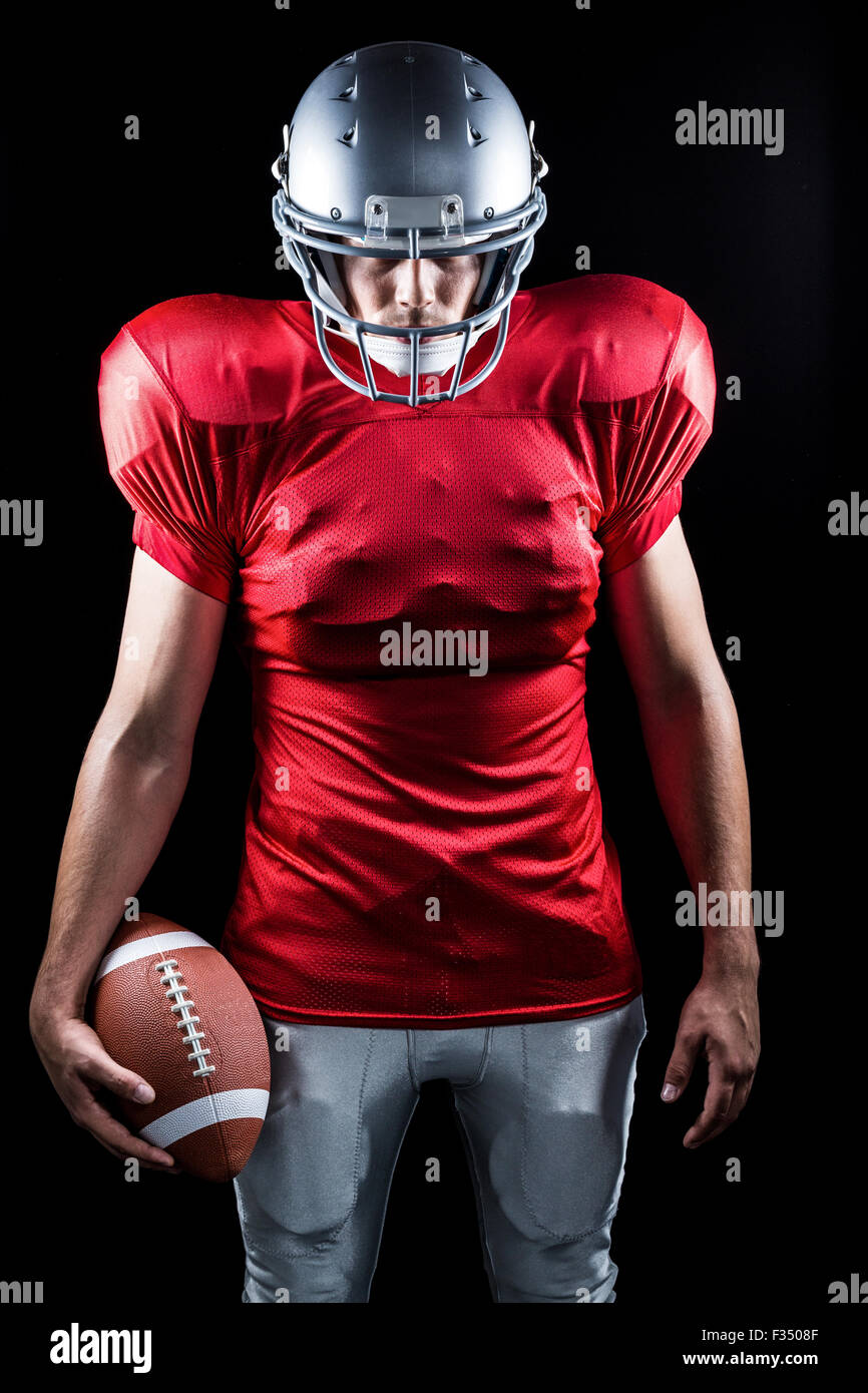 American Football-Spieler mit Ball stehend Stockfoto