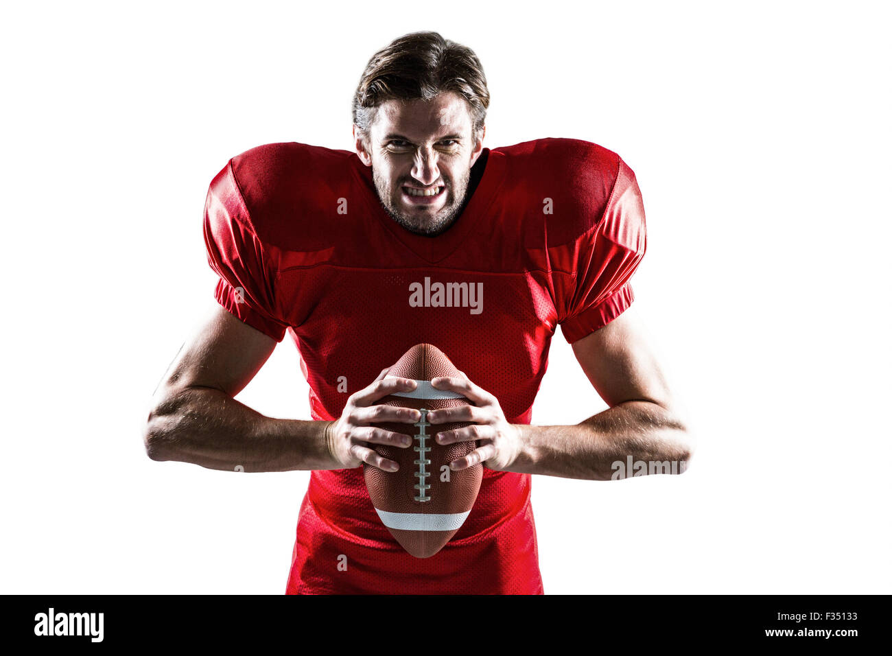 Aggressive American-Football-Spieler in roten Trikots mit ball Stockfoto