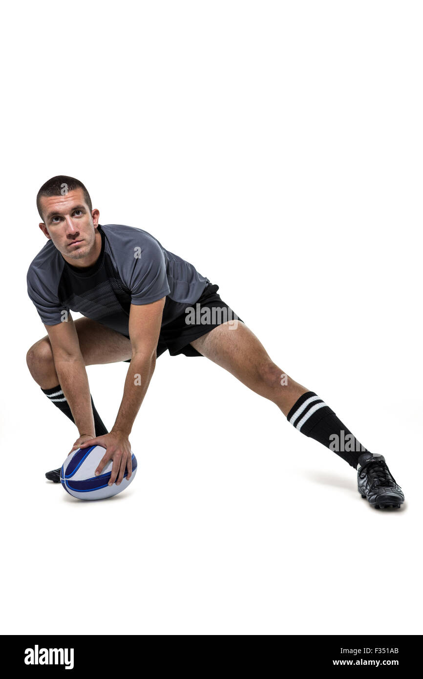 Sportler in schwarzem Jersey stretching mit Kugel Stockfoto