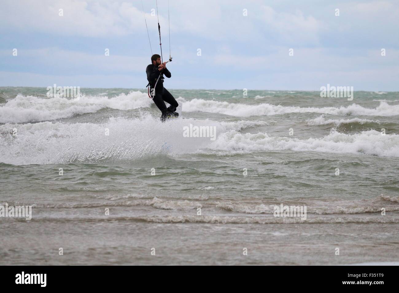 Chicago, USA. 29. September 2015. Ein Kitesurfer geht beim trotzen die wilden Gewässer des Lake Michigan heute im Montrose Beach in der Luft. Starke Winde aus dem Nordosten blies das gesamte Abrufen des Sees bringen hohe Brandung zu Chicagos Stränden. Bildnachweis: Todd Bannor/Alamy Live-Nachrichten Stockfoto