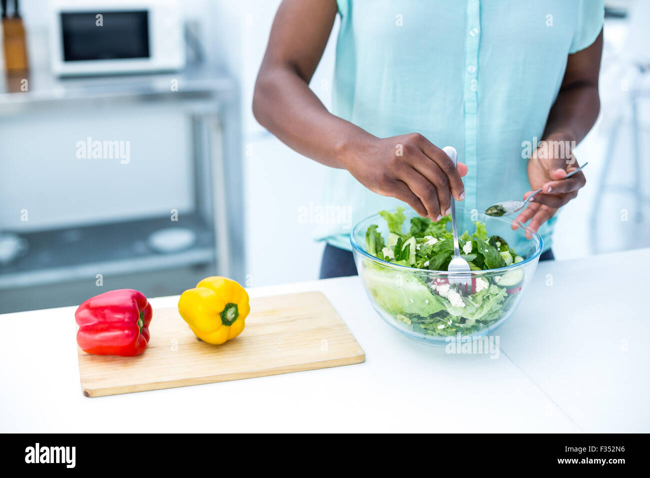 Mittelteil der schwangeren Frau mit Salat Stockfoto