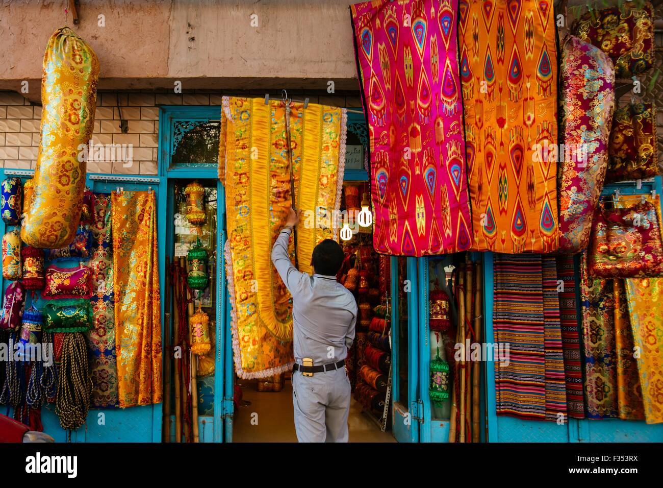 Kashgar, Chinas Xinjiang Uygur Autonome Region. 21. Sep, 2015. Ein Ladenbesitzer hängt ein Stück der Decke in der alten Stadt Kashgar, Nordwesten Chinas Xinjiang Uygur Autonome Region, 21. September 2015. Kashgar, die westlichste Stadt Chinas, war das Zentrum der Uygur Zivilisation seit Jahrhunderten ein Ort, wo Menschen zusammen kamen, um Handel und islamischen Lernens auf die Karawanenwege aus Europa und Persien nach China zu verbreiten. © Zhang Cheng/Xinhua/Alamy Live-Nachrichten Stockfoto