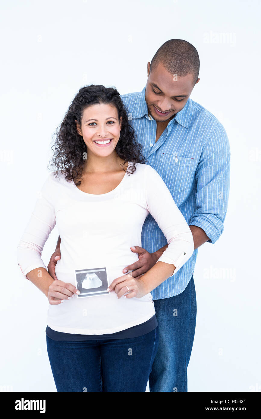 Glückliche Frau mit Ultraschalluntersuchung und Ehemann vor weißem Hintergrund Stockfoto