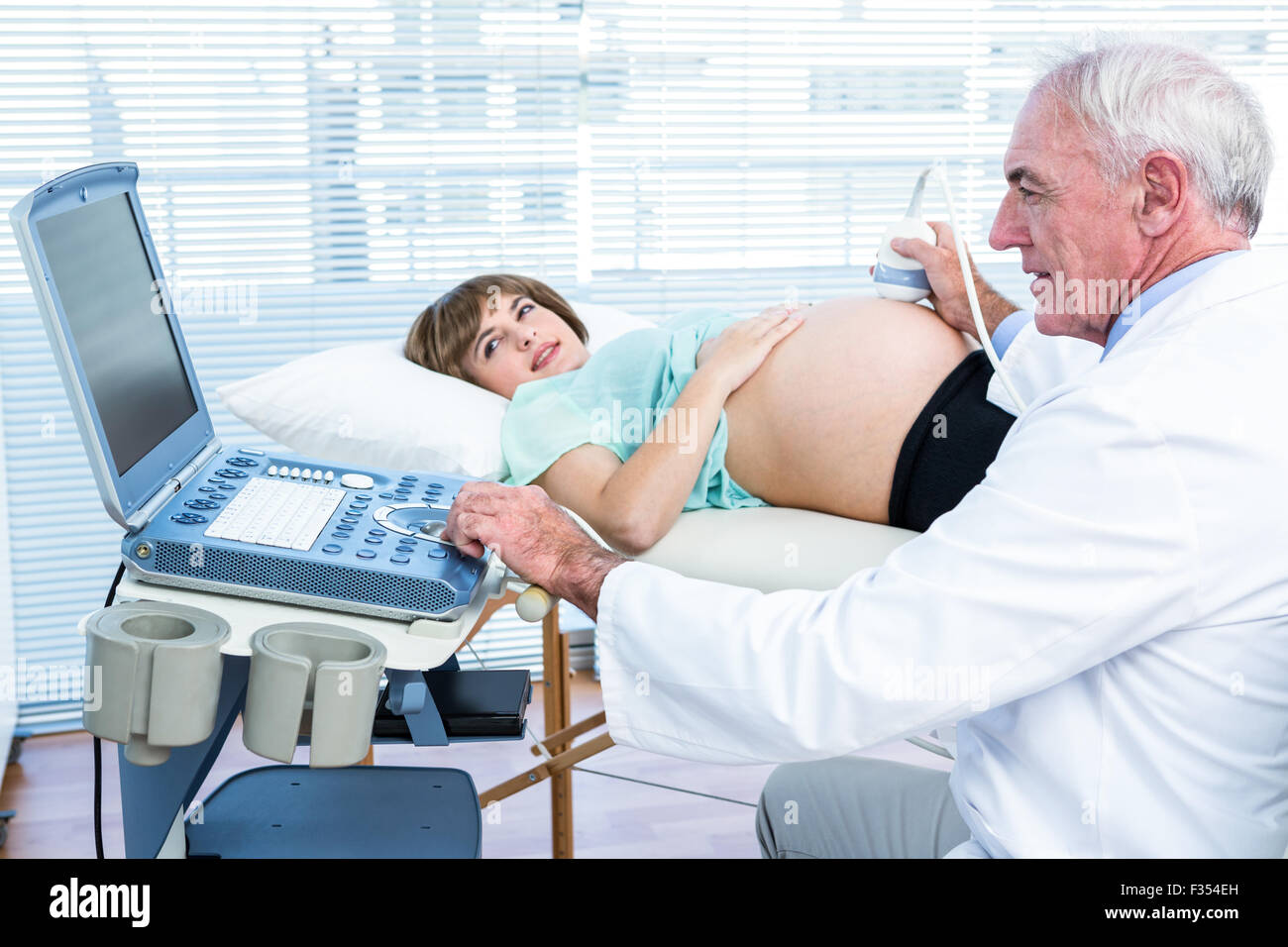 Schwangere Frau und Arzt Blick auf Scan-Maschine Stockfoto