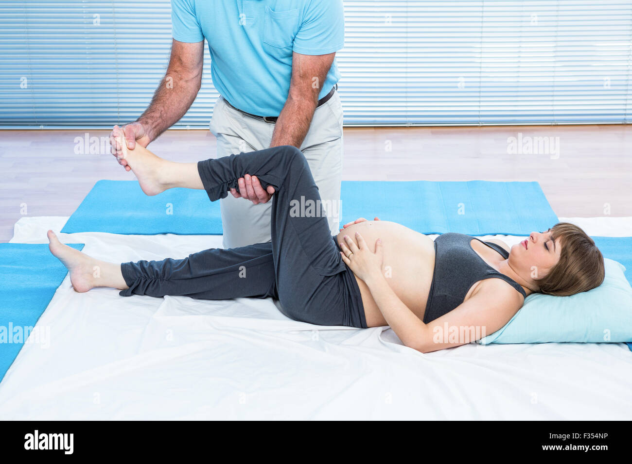 Therapeut, kneten, schwangere Frau auf der Matratze liegend Stockfoto