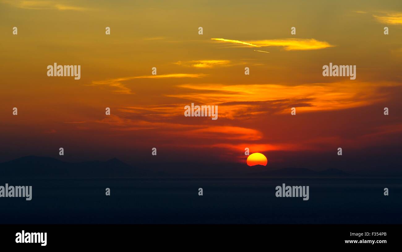 Ein Sonnenuntergang mit der Sonne niedrig am Himmel Santoroni Griechenland Stockfoto