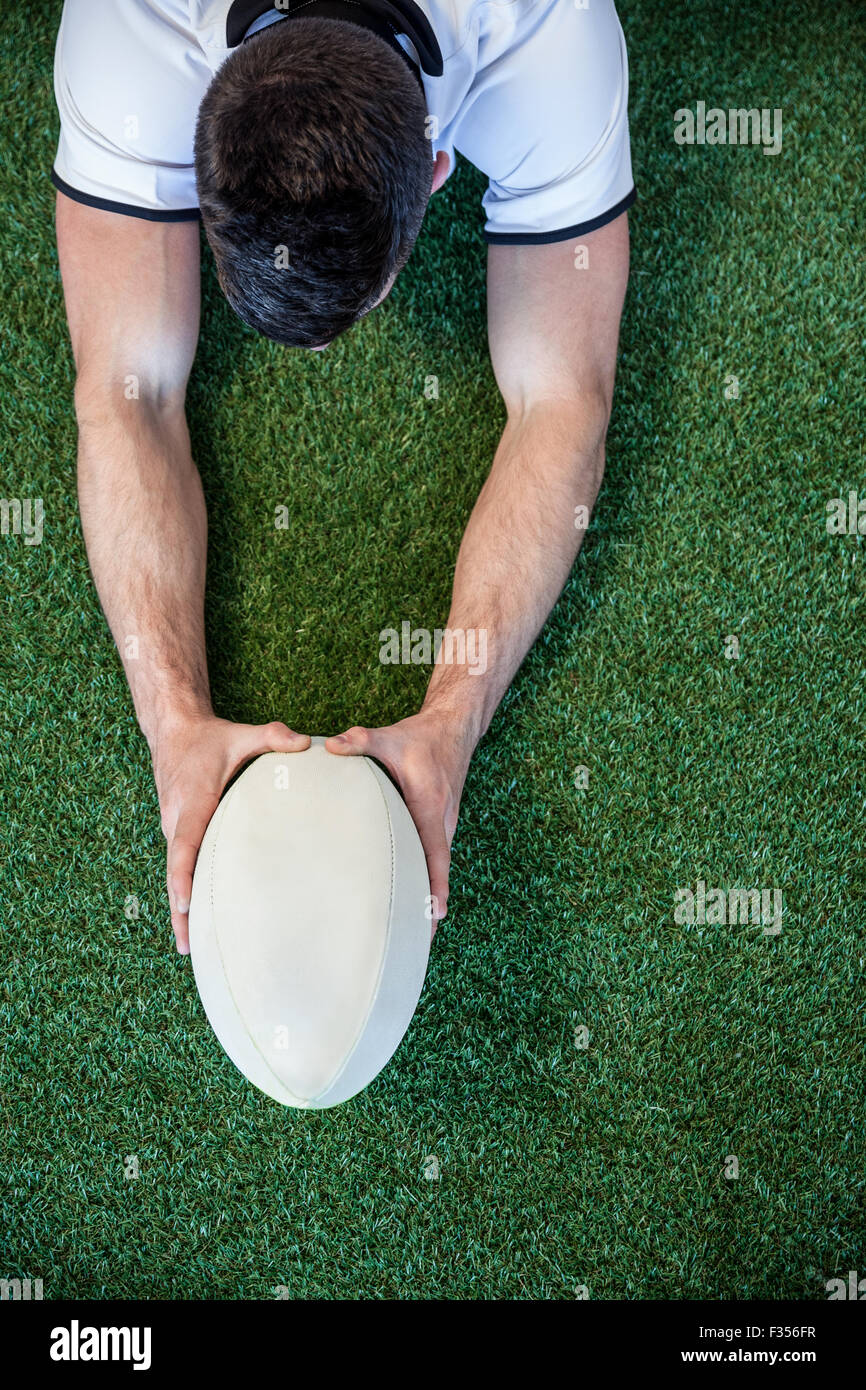 Erhöhte Ansicht der Mann, der Rugby-Ball mit beiden Händen hält Stockfoto