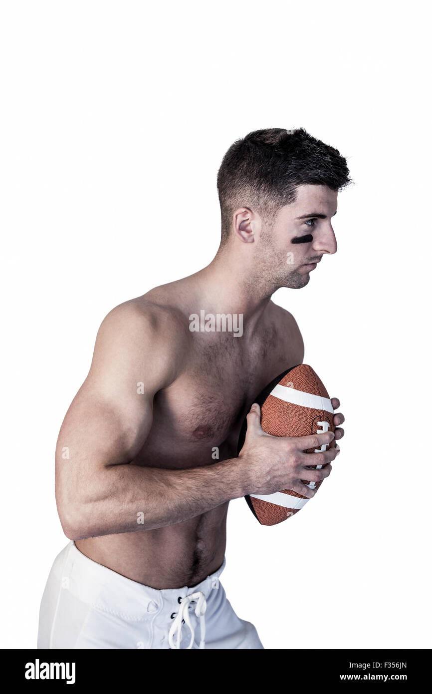 Nackter Oberkörper Rugby-Spieler hält den Ball und die Konzentration Stockfoto