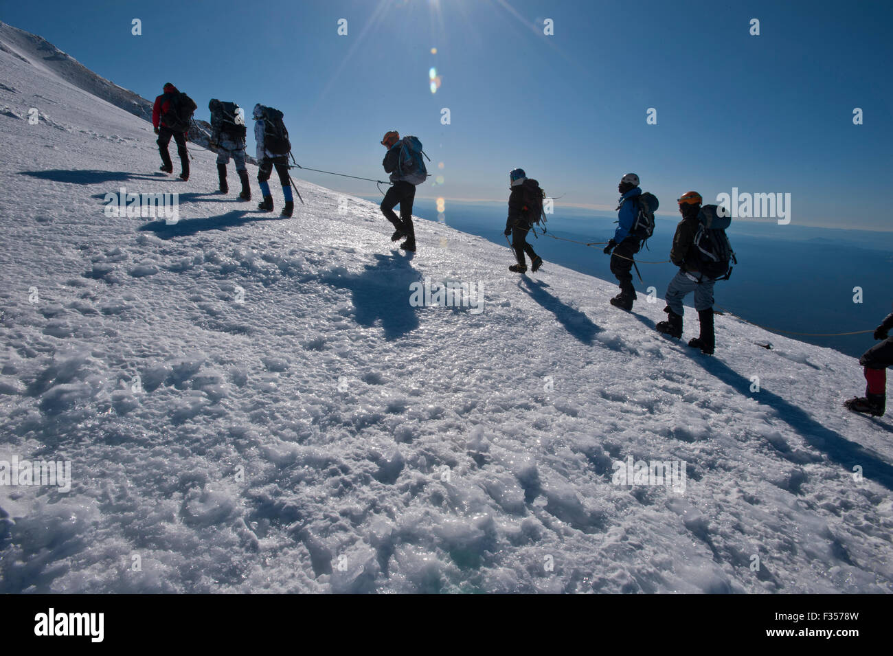 Eine Gruppe von Menschen klettern in zwei Seilschaften einen eisigen Hang des Mount Shasta, Shasta Trinity National Forest, Kalifornien. Stockfoto