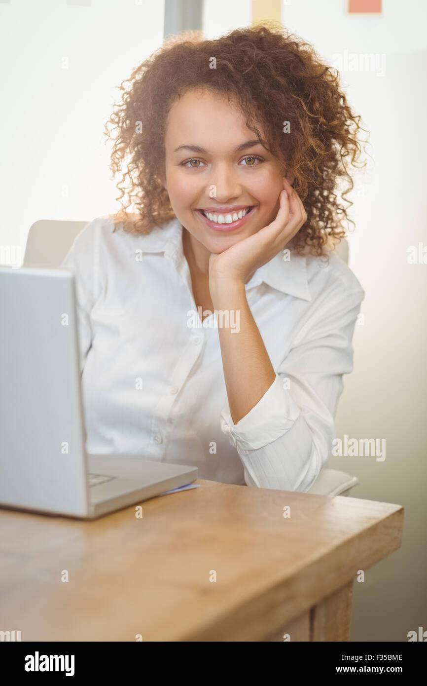 Lächelnde Geschäftsfrau mit Hand am Kinn Stockfoto