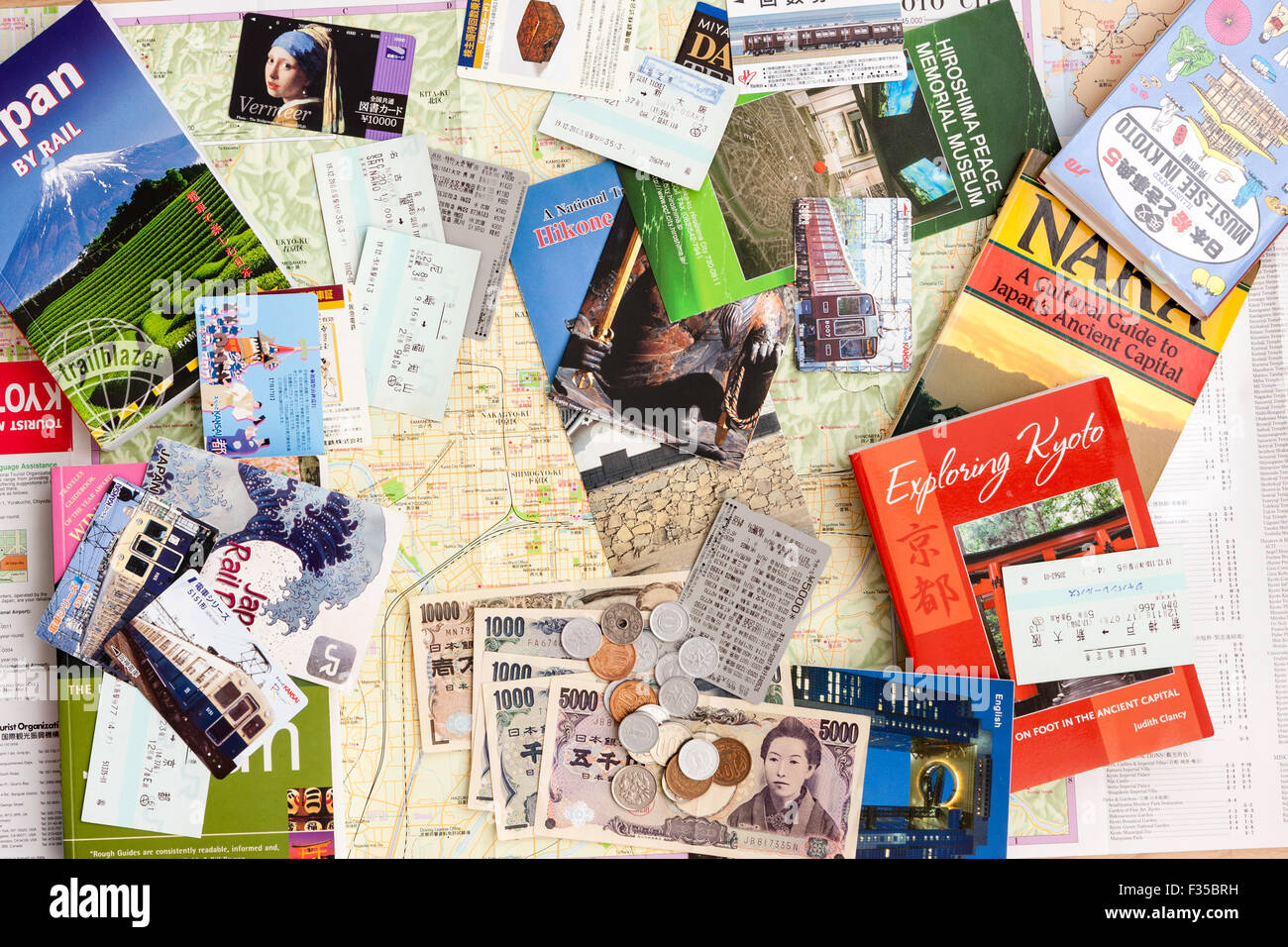 Japanische "Reisen". Karten, Reiseführer, Prospekte, Geld, Japan Rail Pass und Tickets in kleinen Haufen Füllung gesamte Frame verstreut. Kyoto, Nara. Stockfoto