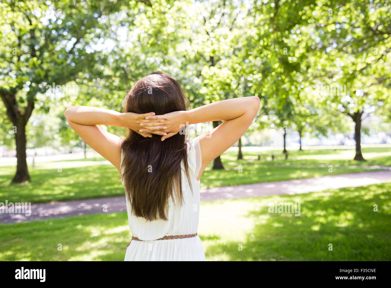 Rückansicht des langen Haaren Frau mit Händen hinter dem Kopf Stockfoto