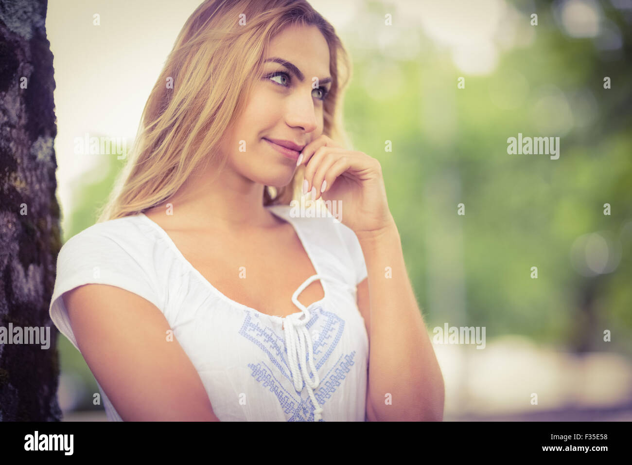 Lächelnde nachdenkliche Frau im park Stockfoto