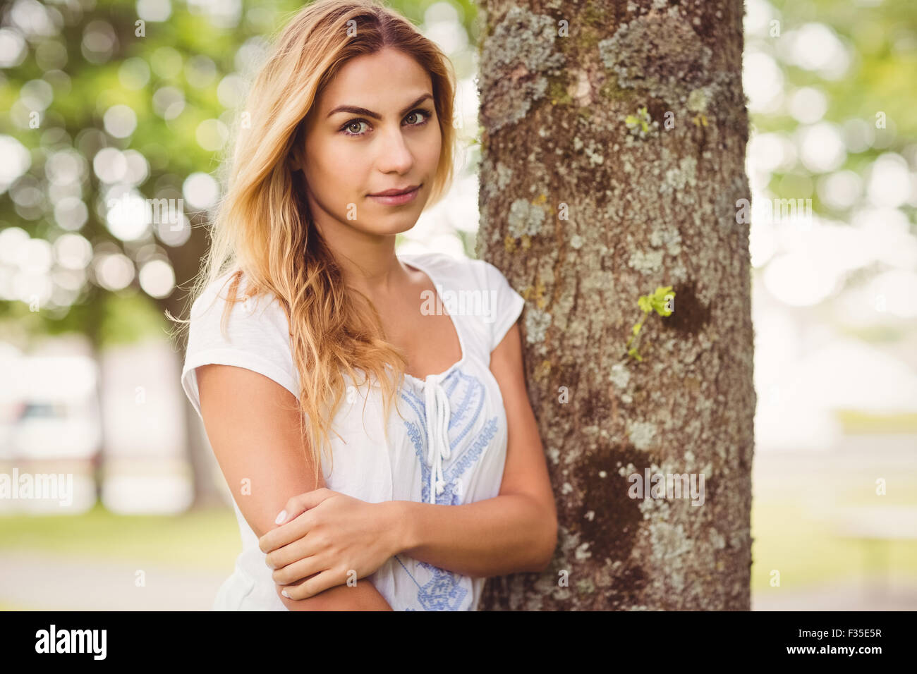 Portrait der schönen Frau Baumstamm stehend Stockfoto